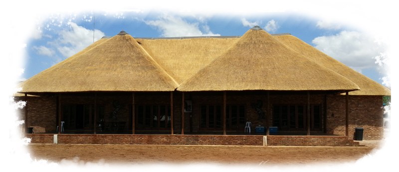 A large new thatch roof over a brick building with an open pavilion